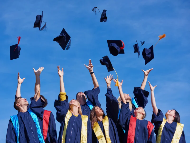 personnes jetant des chapeaux d'étudiants en l'air