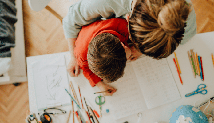 Une mère soutenant l'apprentissage à domicile de son enfant.